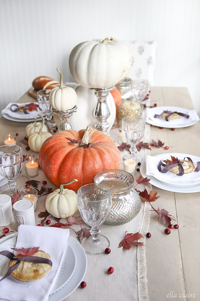 Thanksgiving Tablescape with pumpkins, leaves, berries, and mini pies at each place setting! 