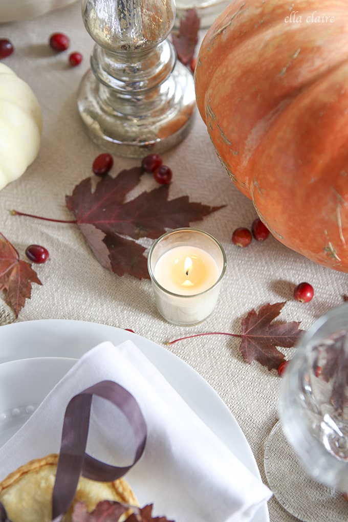 Thanksgiving Tablescape with pumpkins, leaves, berries, and mini pies at each place setting! 