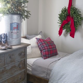 live boxwood wreath in a Christmas Farmhouse little boys room with red, blue, gray, plaid and a Christmas tree in a bucket
