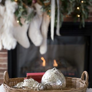 Simple mercury glass ornaments are a perfect holiday accent in front of a cozy fire and Christmas mantel.