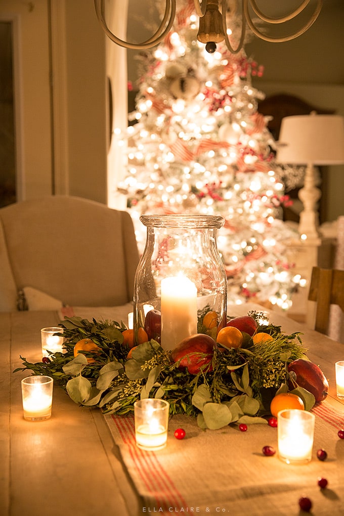 A simple DIY Christmas centerpiece on a table under the glow of the Christmas tree