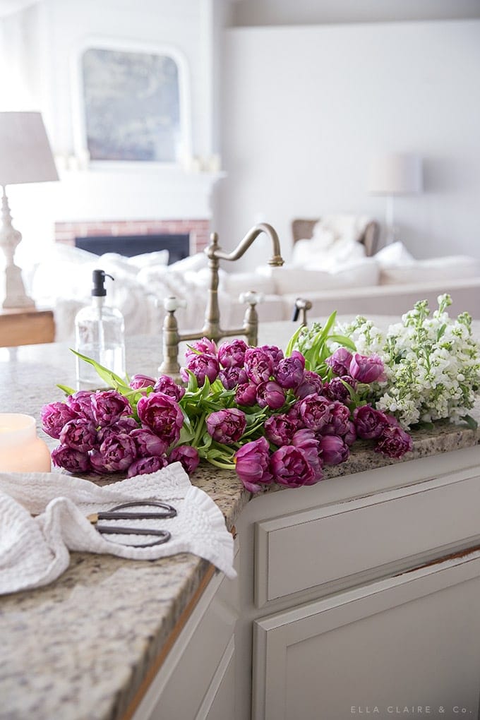 A sink full of fresh spring tulips and flowers- a pretty pop of color while decorating the french country house for the season.