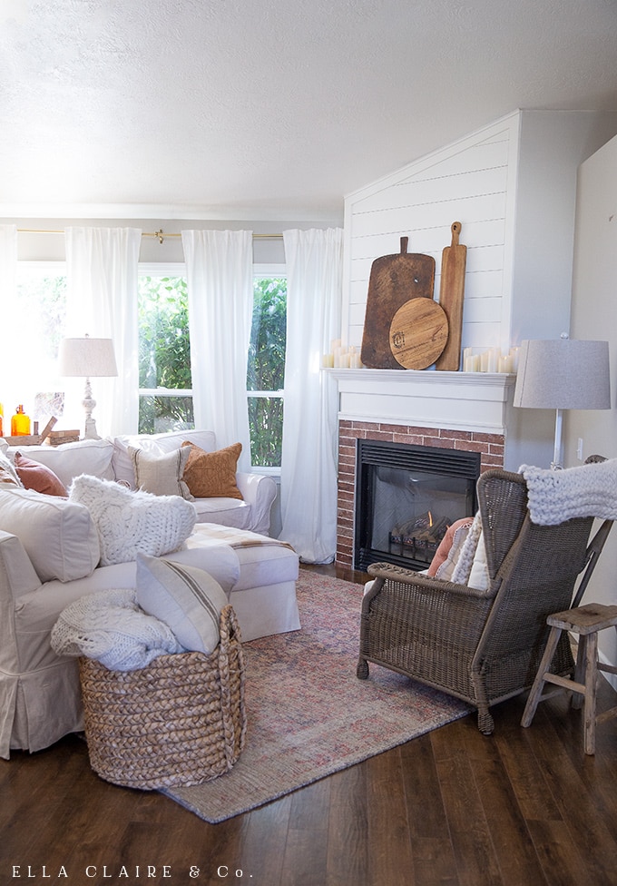 A cozy, rustic fall family room with antique breadboards as the focal point on the mantel.