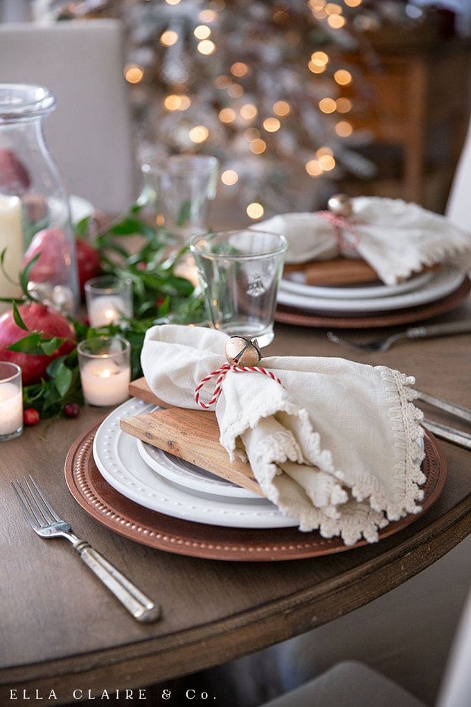Tie a bell onto a napkin for an easy napkin ring and create this DIY Christmas matching vintage bell and candle centerpiece. 