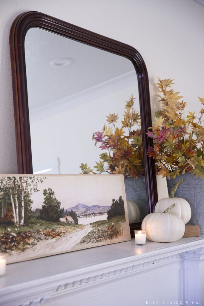 canvas landscape art on mantel decorated for fall