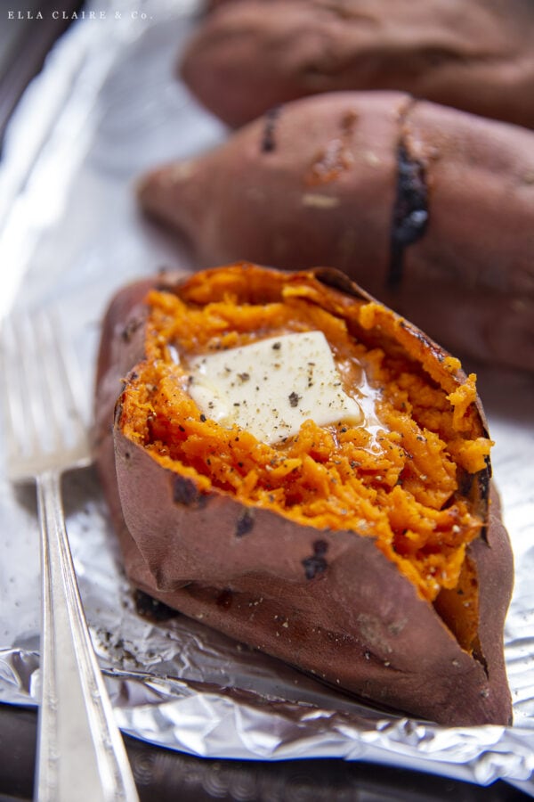 hot baked sweet potato cut open with a pat of butter on top