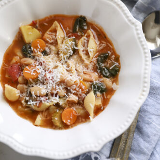 a bowl of minestrone soup with fresh grated parmesan