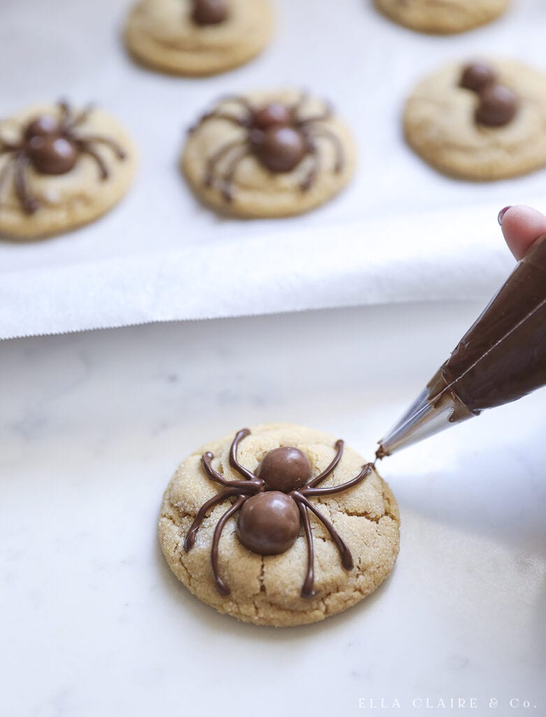 piping the chocolate legs onto the spiders