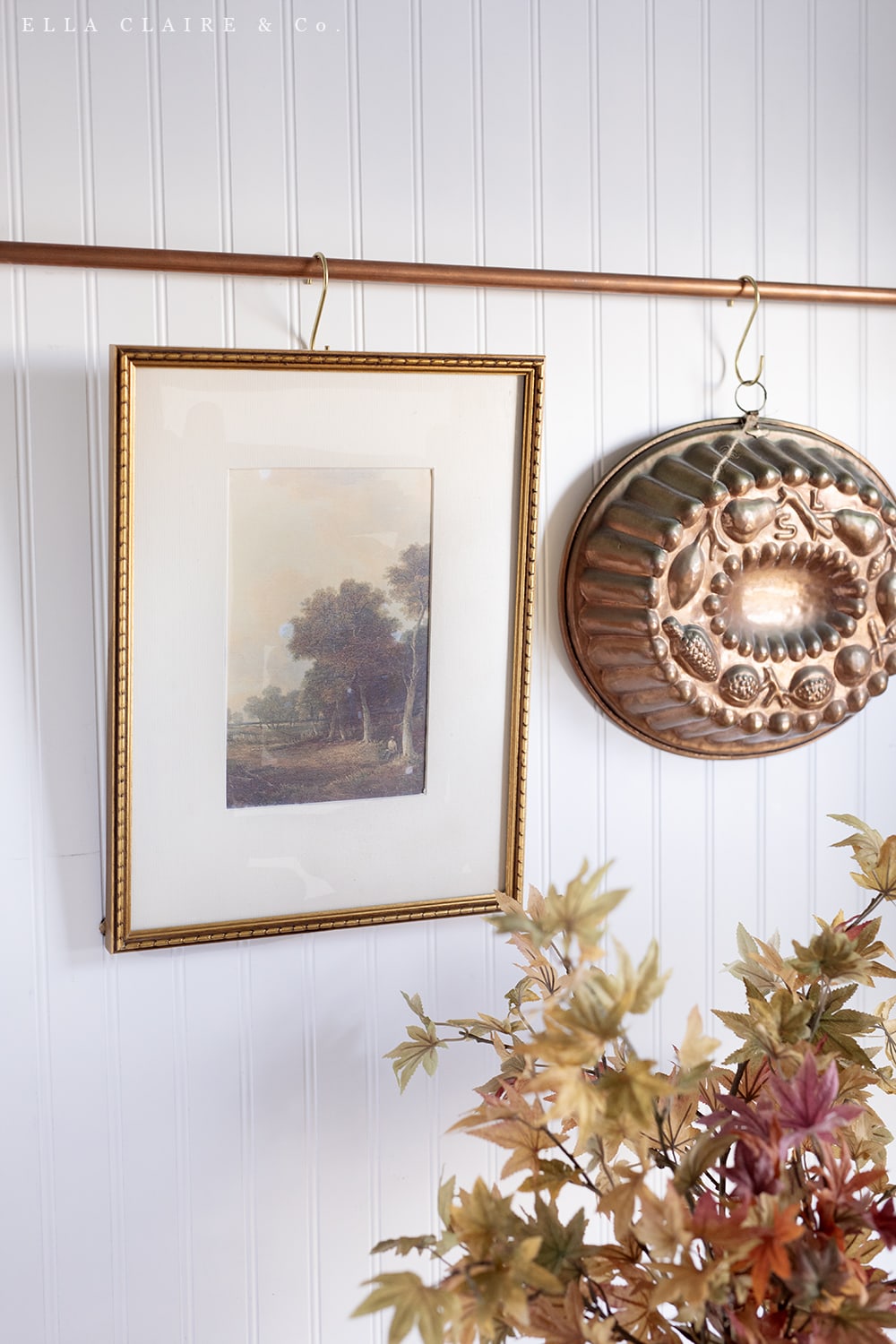 Printable fall trees in vintage frame hung on copper kitchen rod.